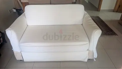 20 dhs Two-seater white slipcovered sofa in fair condition