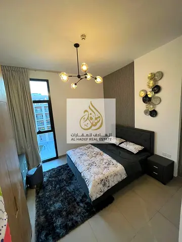 Furnished apartment with a master bedroom, living room, balcony, and two bathrooms, near Dubai exit, at an excellent price.