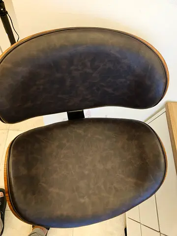 Vintage-style brown leather bar stool with wooden trim.