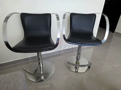 Pair of modern swivel bar stools with chrome arms and footrest