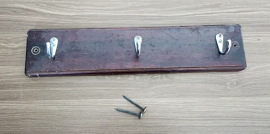 Wooden wall-mounted coat rack with 3 metal hooks — used