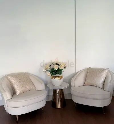 Barrel chairs and round table  flowers as a gift