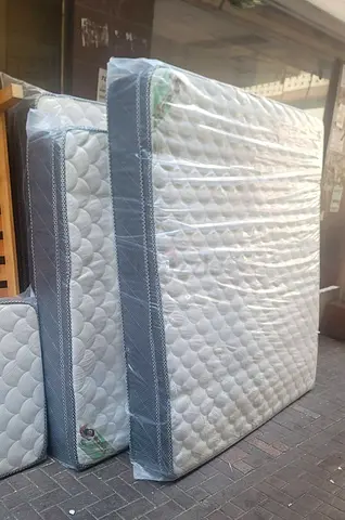 Almost-new single mattress wrapped in protective plastic