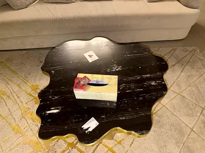 Unique black marble-look sculpted coffee table with brass trim