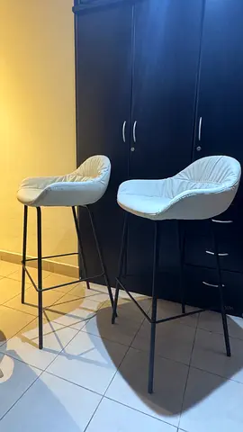 Pair of modern white bar stools with cushioned seats