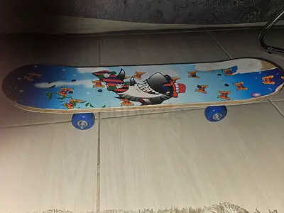 Used kids skateboard with cartoon deck and blue wheels