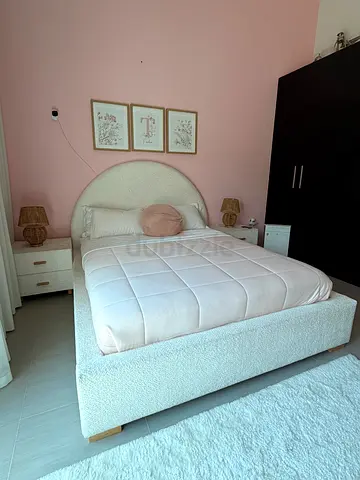 Queen bed with round upholstered headboard with mattress and side tables white color