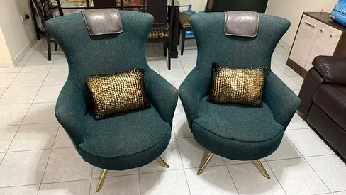 Pair of mid-century modern teal lounge chairs with brass legs