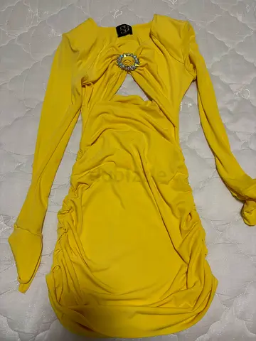 Yellow long-sleeve ruched cocktail dress with jeweled brooch detail