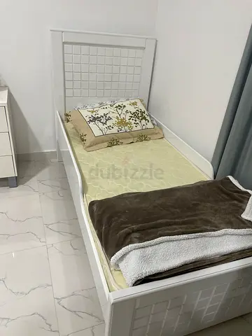 Single white bed frame with headboard and mattress