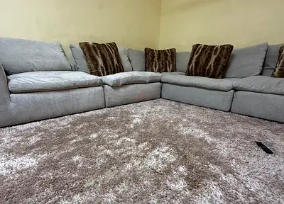 Large Beige Sectional Sofa with Shaggy Brown Rug
