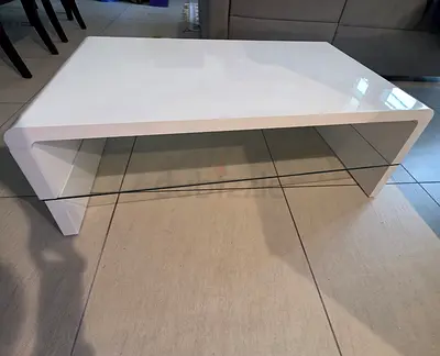Modern white glossy coffee table with glass shelf