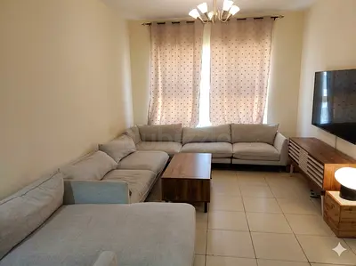 Light grey L-shaped fabric sectional sofa with wooden coffee table and TV unit