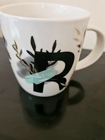 White Ceramic Coffee Mug with Black Handle and Decorative Print