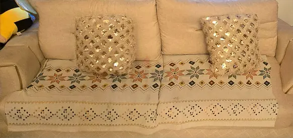 Beige 3-Seater Sofa with Decorative Cushions and Throw Covers . Sofa cum bed.