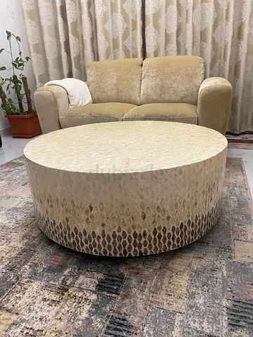 Round upholstered coffee table / ottoman in beige