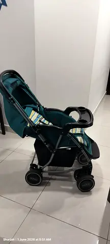 Lightly used teal single stroller with storage basket and canopy