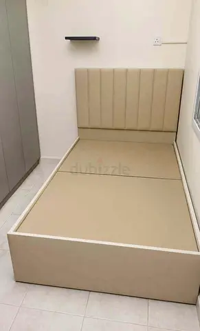 Double beige upholstered bed with padded headboard