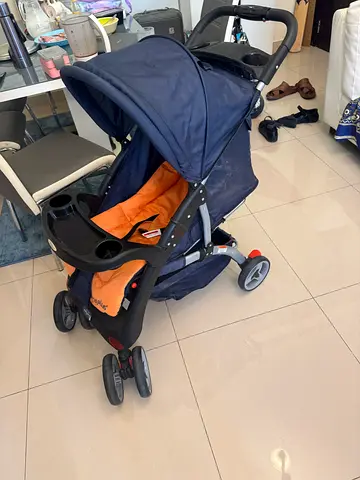 Well-used navy and orange baby stroller with canopy and cup holders