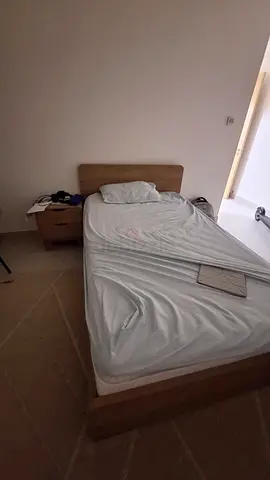 Single wooden bed frame with headboard and mattress