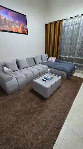 Light grey L-shaped fabric sofa with ottoman - good condition
