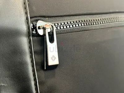 Black nylon backpack with front zip pocket — good condition