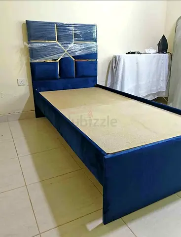 Single blue upholstered bed frame with padded headboard