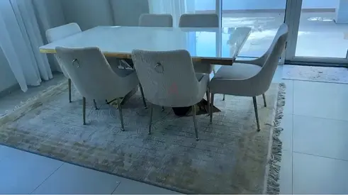 Dining table with 6 upholstered chairs and large area rug