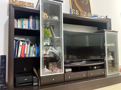 Large dark-wood entertainment center with glass cabinets and drawers