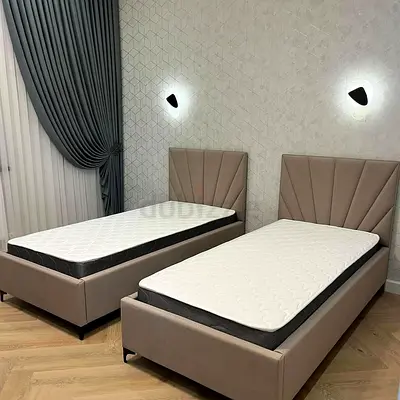 Pair of single upholstered beds with headboards and mattresses