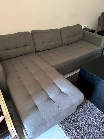 Grey L-shaped tufted fabric sofa