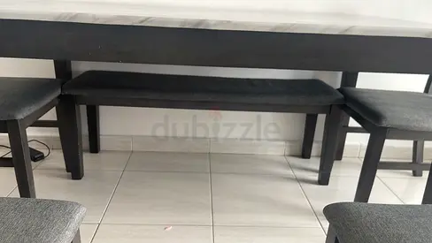 Dark wood dining table with cushioned bench and stools - good condition
