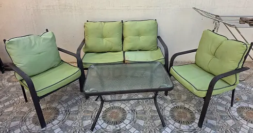 4-piece outdoor patio set with glass table and green cushions