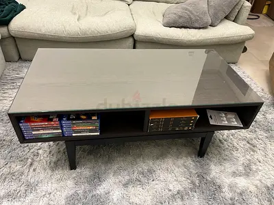 Modern black coffee table with glass top and storage compartments