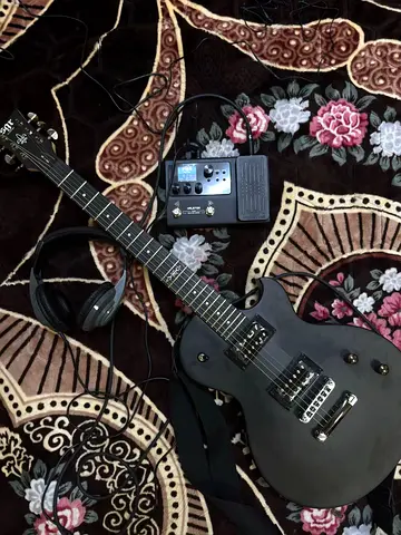 Used solid-body electric guitar with pedals