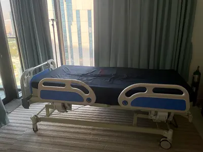 Adjustable hospital bed with mattress. Three adjustable sections with IV pole and side rails.