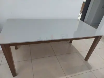 Simple white glass top dining table with wooden legs