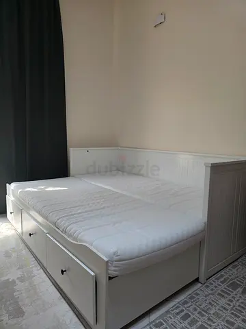 White wooden bed with storage drawers and mattress