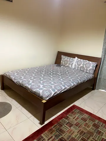 Modern queen-size wooden bed frame with mattress in excellent condition.