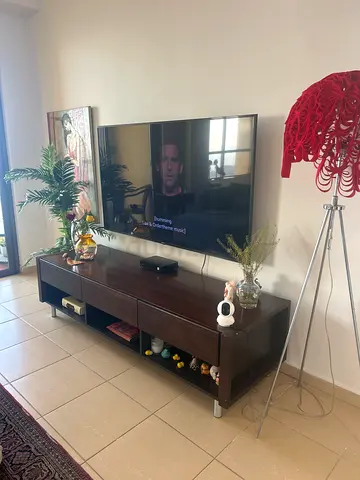 Dark wood TV entertainment unit with storage shelves