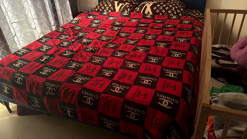Queen bed frame with mattress and patterned bedspread - good condition