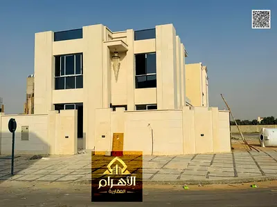 For Sale: Corner Villa on two streets in Al Helio 2 area, Ajman. Prime location directly opposite Azhi Mall. Price includes registration and ownership