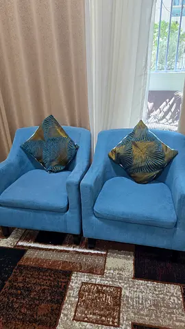 Pair of blue upholstered lounge chairs with cushions