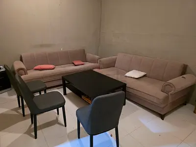 Pair of beige fabric sofas with coffee table and 3 chairs - used