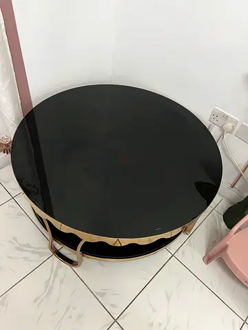 Round black glass coffee table with gold metal frame