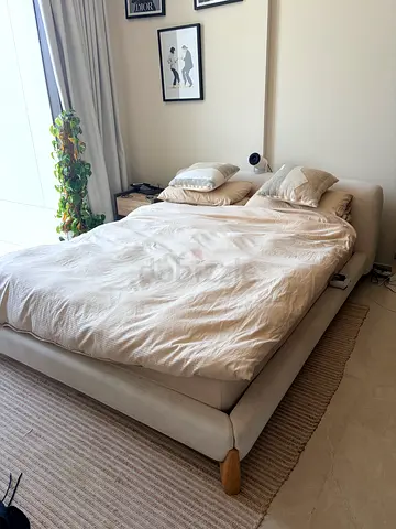Light beige upholstered platform bed with wooden legs — Queen size mattress included