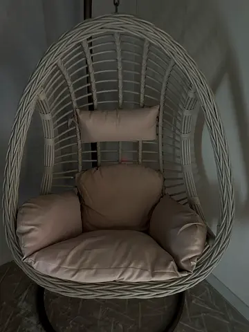 Egg-shaped rattan hanging chair with cushions