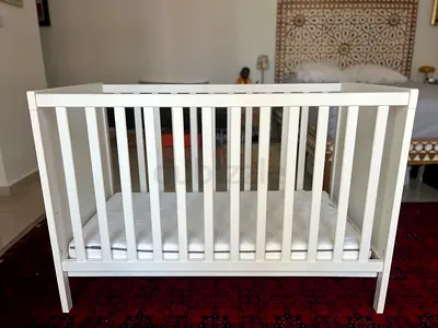 Wooden baby cot in white with mattress