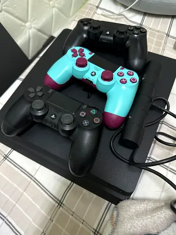 PS4 Slim  is 1 tb with 3 DualShock Controllers and Charging Dock - Good Condition