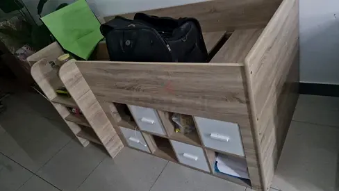Compact wooden storage bed with shelving and drawers.